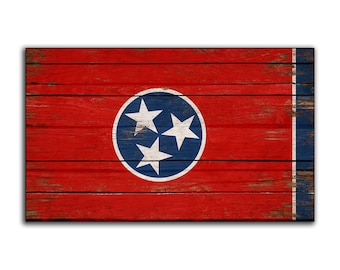 May include: A distressed wood sign with the state flag of Tennessee. The flag features a blue circle with three white stars on a red background.