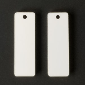 May include: Two white rectangular blank tags with a hole at the top for hanging.