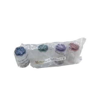 May include: A clear plastic bag containing four small, clear plastic containers with colored lids. The lids are blue, green, purple, and red. The containers are labeled with text.