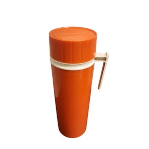 May include: Orange and white thermos with a handle. The thermos has a white lid and a white band around the middle.