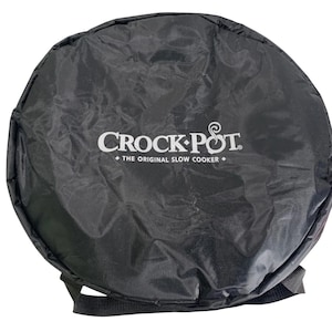 May include: Black Crock-Pot slow cooker carrying case. The case is round with a black strap and the Crock-Pot logo in white. The text reads "CROCK-POT. THE ORIGINAL SLOW COOKER."