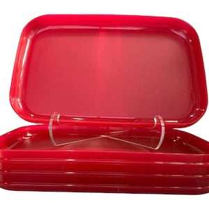 May include: A bright red rectangular container with a hinged lid. The container is made of a glossy material and has rounded corners. The lid is open, revealing the interior. The container is designed for storage.