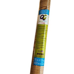 May include: A roll of wood grain adhesive covering with a label reading Quick Cover, Shelf & Drawer Liner, Washable & Durable, Easy to Apply & Remove, Kittrich Corporation, and dimensions of 18 in. x 1.5 yd. The label features blue, green, and white text.