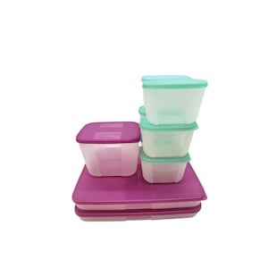May include: A set of clear plastic food storage containers with purple and teal lids. The containers are stacked on top of a large purple tray. The containers are various sizes and shapes, suitable for storing food.