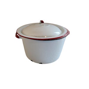 May include: White enamelware pot with a lid. The pot has a red trim around the rim and handle. The pot is round with a slightly flared shape. The lid has a small handle. The pot appears to be vintage.