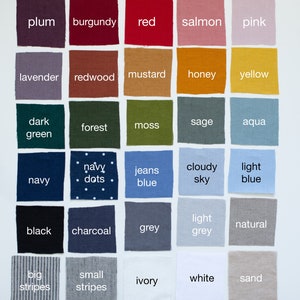 Op de afbeelding: Een kleurenkaart met stofstalen met namen voor elke kleur, waaronder pruim, bordeauxrood, rood, zalm, roze, lavendel, redwood, mosterd, honing, geel, donkergroen, bos, mos, salie, aqua, marine, marine met stippen, jeansblauw, bewolkte lucht, lichtblauw, zwart, antraciet, grijs, lichtgrijs, naturel, brede strepen, smalle strepen, ivoor, wit en zand.