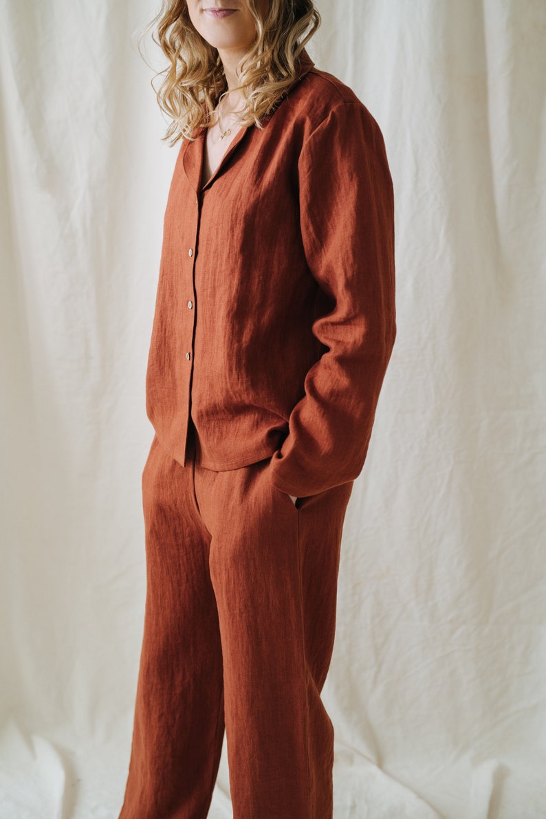 Puede incluir: Un conjunto de camisa y pantal&oacute;n de lino de color &oacute;xido. La camisa tiene cuello y mangas largas. El pantal&oacute;n tiene pierna recta.