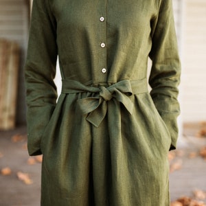 May include: A long-sleeved, green linen dress with a button-up front and a self-tie belt at the waist.