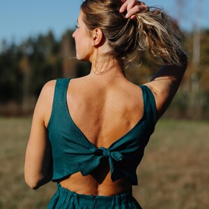 Peut inclure: Ensemble deux pi&egrave;ces de couleur teal. Le haut sans manches pr&eacute;sente un dos bas et un n&oelig;ud. La jupe assortie est taille haute. Fabriqu&eacute; dans un tissu doux, cet ensemble est id&eacute;al pour l'&eacute;t&eacute;.