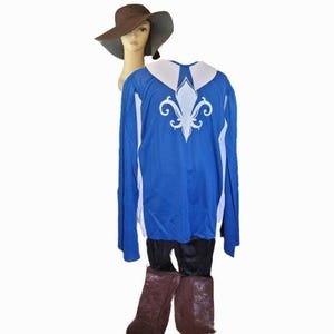 Puede incluir: Un conjunto de disfraz con una camisa azul de manga larga con cuello blanco y diseño de flor de lis. El atuendo incluye pantalones negros, botas marrones y un sombrero marrón. El disfraz se exhibe en una cabeza de maniquí.