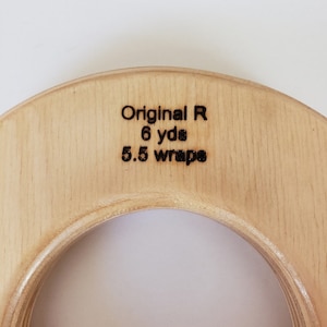 May include: A wooden knitting ring with the text "Original R 6 yds 5.5 wraps" engraved on the top.