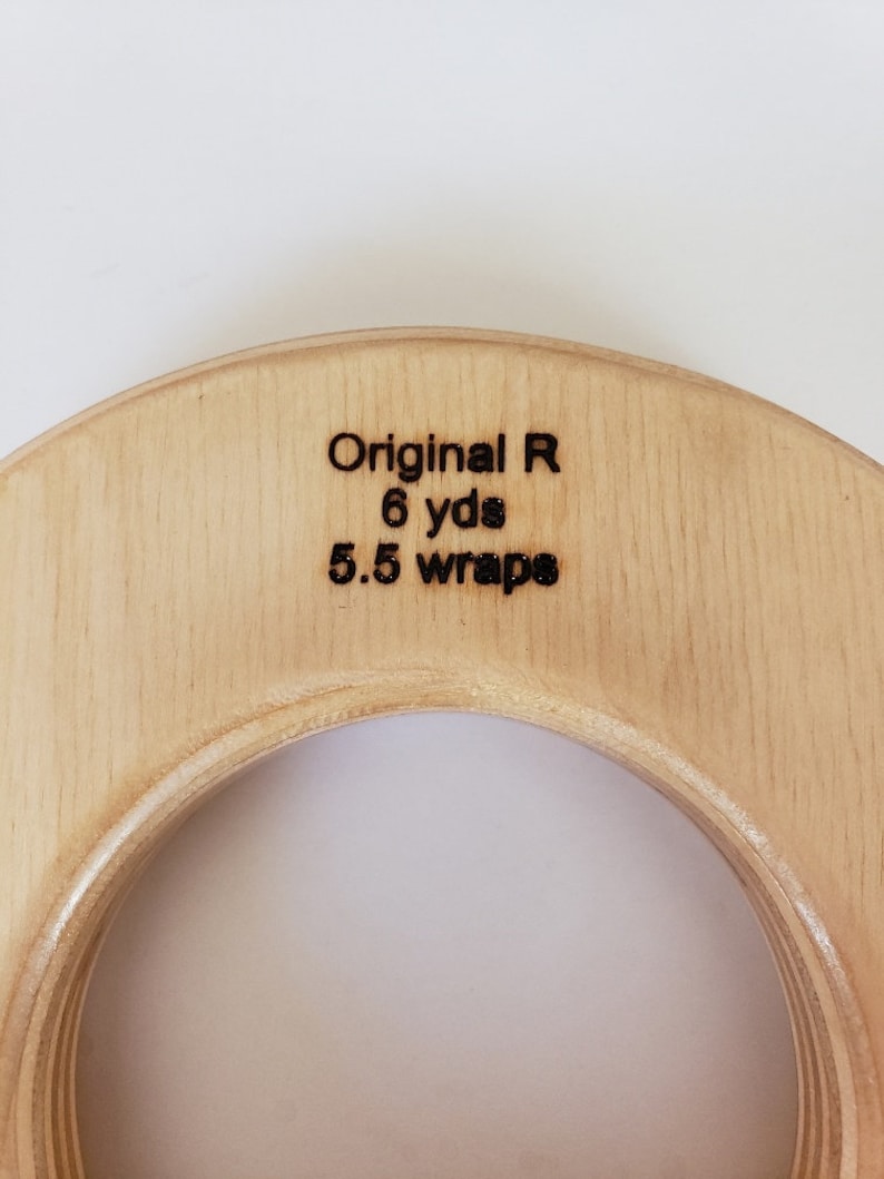 May include: A wooden knitting ring with the text "Original R 6 yds 5.5 wraps" engraved on the top.