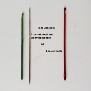 May include: Three tools for crafting: a green crochet hook, a silver weaving needle, and a red locker hook. Tool Choices: Crochet hook and weaving needle OR Locker hook.
