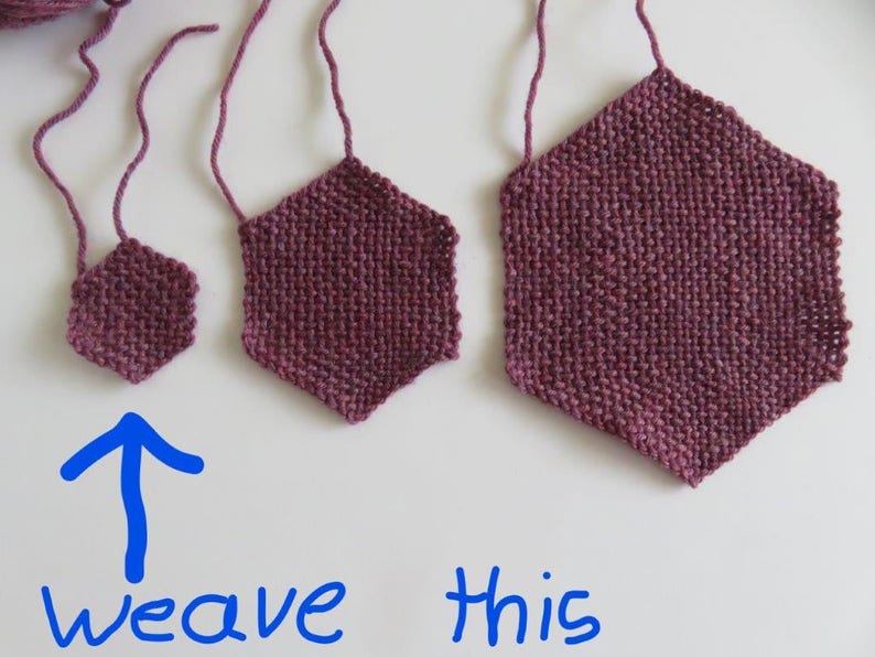 May include: Three woven hexagonal shapes in various sizes, made with a deep burgundy yarn. The smallest hexagon is at the bottom of the image with an arrow pointing up and the words "weave this" written below it.