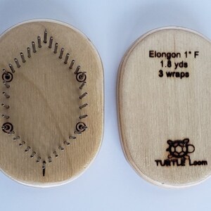 May include: A wooden oval-shaped knitting loom with 32 pegs. The loom is labeled "Elongon 1" F 1.8 yds 3 wraps" and "TURTLE LOOM" with a turtle logo.