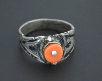 Könnte beinhalten: Ein silberner Ring mit einem komplizierten Design und einem leuchtend orangefarbenen Stein in der Mitte.