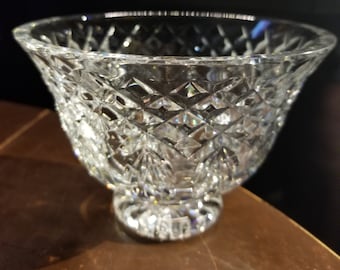 May include: A clear glass bowl with a cut crystal design. The bowl has a wide, shallow base and a flared rim.