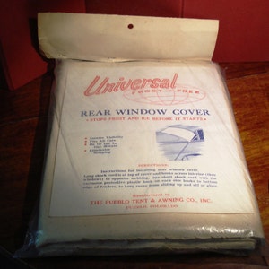 May include: A white package with a white and red label that reads "Universal Frost-Free Rear Window Cover Stops Frost and Ice Before It Starts." The label also includes instructions for installing the cover and a list of features, including "Insures Visibility", "Fits All Cars", "On Or Off In One Minute", and "Eliminates Scraping". The label also states "Manufactured by The Pueblo Tent & Awning Co., Inc. Pueblo, Colorado."