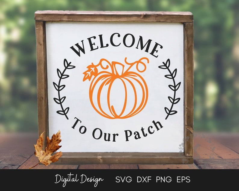 May include: A white wooden sign with a black and orange pumpkin design. The sign reads "Welcome to Our Patch" with a wreath of leaves around the pumpkin.