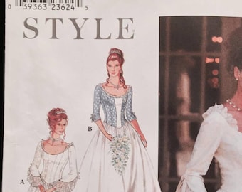 May include: A Simplicity sewing pattern for two wedding dresses. The pattern is for sizes 8-18. The dress on the left is a white gown with a lace trim and a scoop neckline. The dress on the right is a white gown with a lace trim and a square neckline. The pattern number is 9025.