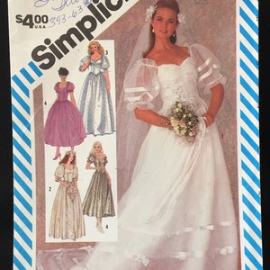 Puede incluir: Un patrón de costura Simplicity para un vestido de novia con escote de corazón y mangas abullonadas. El patrón incluye cuatro estilos de vestidos diferentes, incluyendo un vestido de bola, un vestido de princesa y un vestido simple de línea A. El número del patrón es 6241.