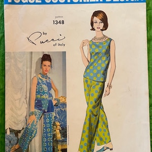 Puede incluir: Patrón de diseño Vogue Couturier vintage 1348 de Pucci of Italy. La portada presenta ilustraciones de dos mujeres con atuendos estampados. Uno es azul con lunares amarillos, el otro azul con diseños geométricos. El texto "Vogue Couturier Design" está en la parte superior.