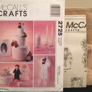May include: A wedding themed craft pattern set with instructions for making a cake, a picture frame, a candle, a bouquet, and a box. The pattern is from McCall's Crafts and the pattern number is 2725.