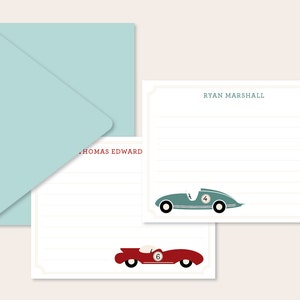 May include: Two blank stationery cards with a blue and red race car illustration. The top card has the name "RYAN MARSHALL" printed on it. The bottom card has the name "THOMAS EDWARD" printed on it. The cards are accompanied by a light blue envelope.