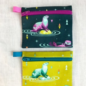 Monedero con cremallera, tarjetero, funda para auriculares y soporte para iPod Tula Pink Otters (color a elegir)