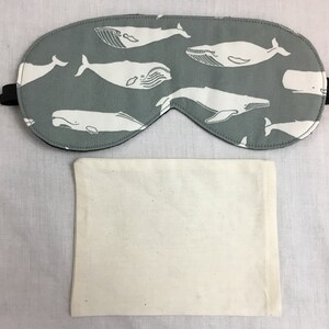 Puede incluir: Una m&aacute;scara para dormir gris con un patr&oacute;n de ballena blanca. La m&aacute;scara est&aacute; hecha de tela suave y tiene una correa el&aacute;stica. Viene con una bolsa de algod&oacute;n blanca.