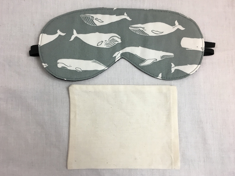 Puede incluir: Una m&aacute;scara para dormir gris con un patr&oacute;n de ballena blanca. La m&aacute;scara est&aacute; hecha de tela suave y tiene una correa el&aacute;stica. Viene con una bolsa de algod&oacute;n blanca.