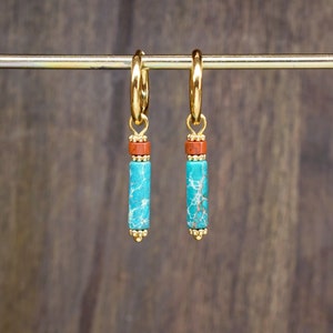 Puede incluir: Un par de pendientes de aro de oro con detalles de piedras turquesa y naranja.