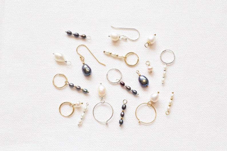 May include: Assortment of pearl and black bead jewellery making supplies, including hoops, earring findings, and strands of pearls and beads.