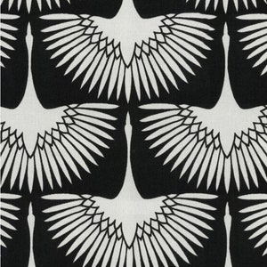 Puede incluir: Tela negra y blanca con un patr&oacute;n repetido de grullas estilizadas con las alas extendidas. Las grullas son blancas y el fondo es negro.