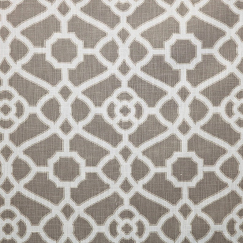 May include: A brown fabric with a white geometric pattern. The pattern is a repeating design of interlocking circles and squares.