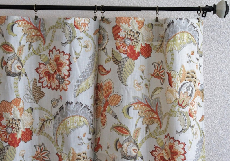 May include: Curtains featuring a floral design in shades of orange, red, green, and grey. The curtains are made from a lightweight fabric with a subtle sheen.