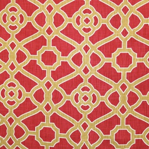 May include: Red fabric with a gold geometric pattern. The pattern is a repeating design of squares and circles.