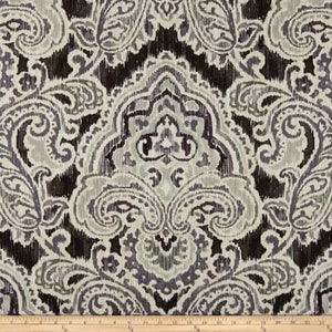 K&ouml;nnte beinhalten: Ein schwarzer und wei&szlig;er Stoff mit Paisley-Muster und einem dezenten Glanz. Der Stoff zeigt ein gro&szlig;es, kompliziertes Paisley-Muster in der Mitte, umgeben von kleineren Paisley-Motiven.