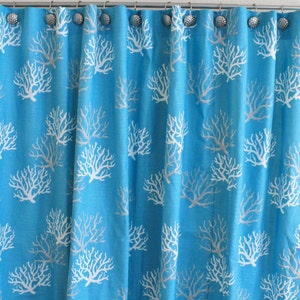 Puede incluir: Una cortina de ducha turquesa con un patr&oacute;n de arrecife de coral blanco. La cortina tiene ojales plateados y est&aacute; hecha de una tela suave y texturizada.