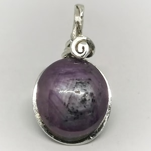 Könnte beinhalten: Ein Anhänger aus violettem Edelstein mit einer silbernen Fassung und einem Spiraldesign. Der Anhänger befindet sich auf einem weißen Hintergrund.