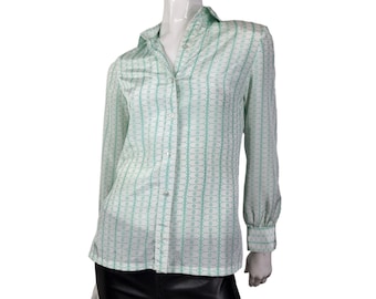 Puede incluir: Una camisa blanca de manga larga con botones y un estampado geométrico verde.