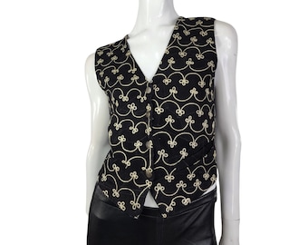 May include: A black sleeveless vest with a gold embroidered pattern of swirling lines and loops.