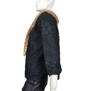 May include: A black, textured,  jacket with a brown fur collar. The jacket has a  three-quarter sleeve and a  boxy fit.