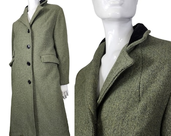 May include: A long, green tweed coat with a black collar and button closure. The coat has a single pocket on the left side and a slightly flared hem.
