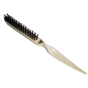 May include: A beige-colored hair brush with black bristles. The brush has a long, tapered handle with the word "Avon" printed on it. The bristles are densely packed and appear to be made of natural fibers.