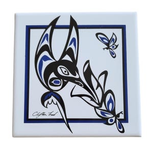 Puede incluir: Azulejo de cerámica cuadrado con fondo blanco, borde azul y diseño de pájaro y mariposa en negro y azul. La obra está firmada "Clifton Fred" en la esquina inferior izquierda.
