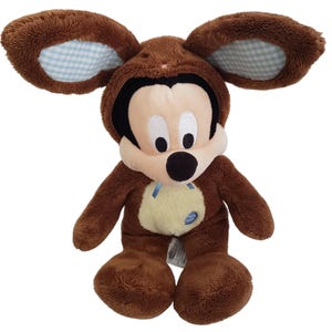 Pode incluir: Um brinquedo de pel&uacute;cia marrom do Mickey Mouse vestindo uma fantasia de urso marrom com orelhas grandes. O interior das orelhas tem um padr&atilde;o xadrez azul claro e branco. O brinquedo tem um rosto creme, um nariz preto e olhos brancos grandes.