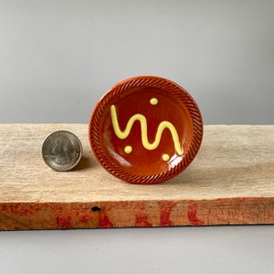 Miniature, traditional Redware Earthenware crock plate with primitive slip trailed  decoration and traditional coggled (roulette) edge