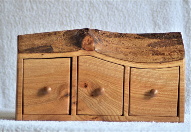 A Rustic three drawer boxchest cut from a solid Elm log with feature bark edge.