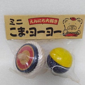 May include: Two wooden spinning tops, one with a blue and red design and a white string, and the other with a yellow and blue design. The tops are packaged in a clear plastic bag with a brown cardboard label that reads "こま・ヨーヨー" and "えんにち大将".